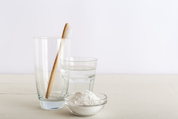 Bamboo toothbrushes, glass of water, dentifrice tooth powder on white background. Biodegradable natural bamboo toothbrush. Eco friendly, Zero waste, Dental care Plastic free concept. Morning routine