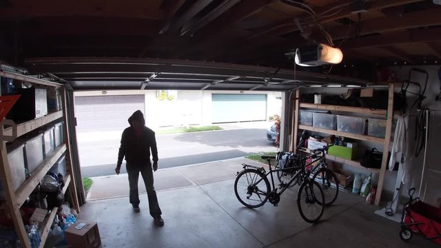 Person stealing bicycle from garage, surveillance camera view