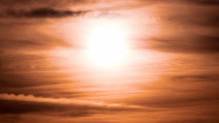 Naklejka na ściany i meble Sun shining through clouds at sunset