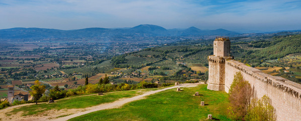 Panoramic view of Umbria countryside with St Francis Basilica from Assisi ancient walls - obrazy, fototapety, plakaty