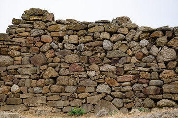 The wall of the old fortress, made of stone. Background from an old stone.