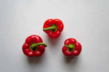 Three red bell peppers isolated on white background from a high angle view 