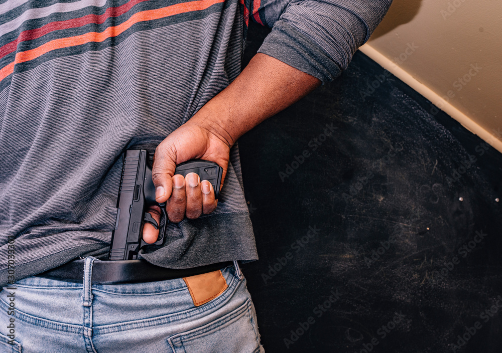 Wall mural conceal carry concept african american male with handgun behind back