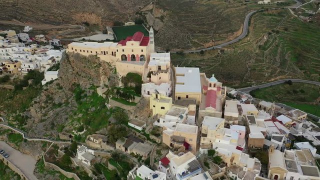Aerial drone video of iconic uphill catholic settlement of ano Syra featuring church of Saint George at sunset with beautiful colours, Syros or Siros island, Cyclades, Greece