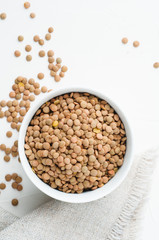 Dried green lentils on a white plaster textured background