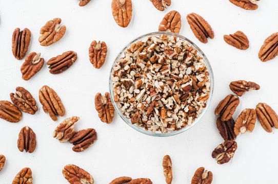 chopped pecans for baking on a white textured background