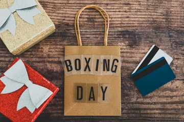 Boxing day shopping bag next to presents and payment or gift cards