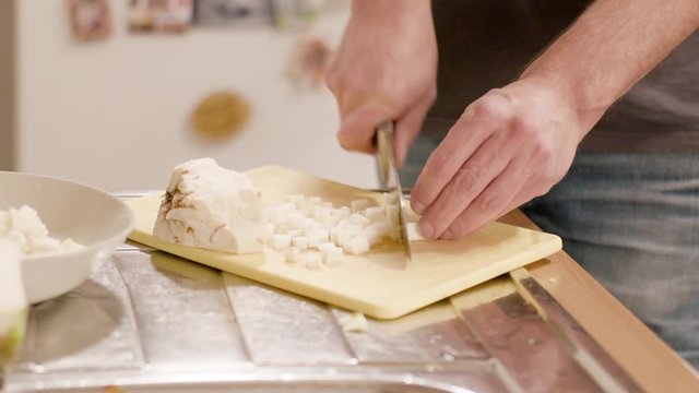 Young man chopping celery on a board