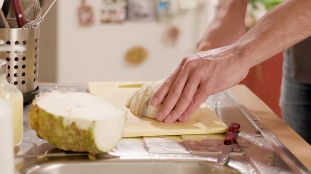 Young man chopping celery on a board