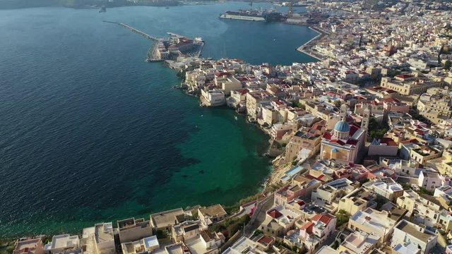 Aerial drone video of picturesque district built by the sea of Vaporia in main town of Syros or Siros island Ermoupolis and famous church of Agios Nikolaos, Cyclades, Greece