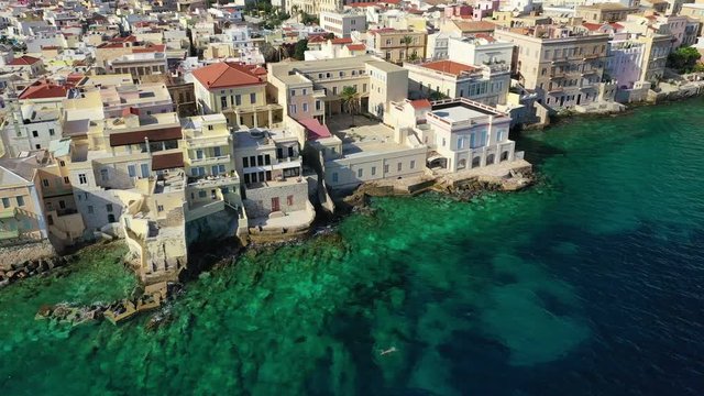 Aerial drone video of picturesque neoclassical houses district built by the sea of Vaporia in main town of Syros or Siros island Ermoupolis near famous church of Agios Nikolaos, Cyclades, Greece