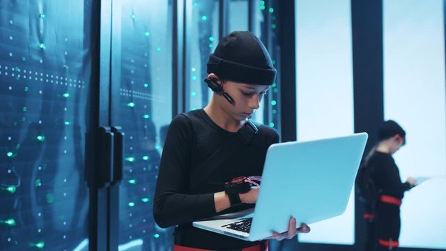 Serious spy kid boy typing program code on laptop copying server data information performing secret team operation in database.