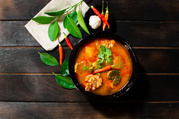 Chicken curry hatching on a black wooden background