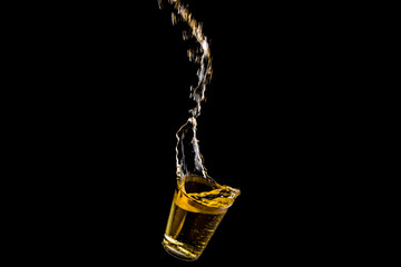 Shot of liquor falling with trailing liquid