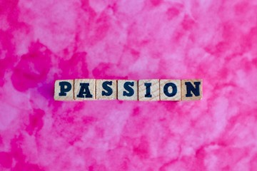 Passion word made with wooden blocks on pink background