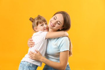 Portrait of happy mother and daughter on color background