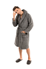 Fototapeta premium Handsome man in bathrobe on white background