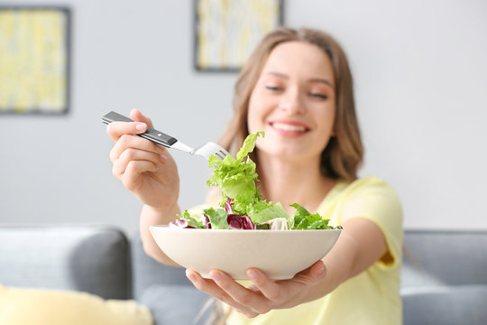 Woman with healthy vegetable salad at home, closeup