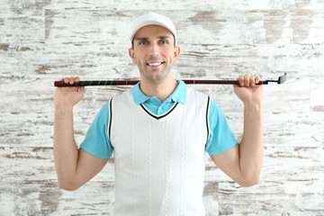 Handsome male golfer on wooden background