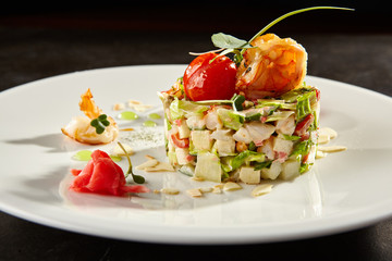 Olivier salad with crab meat and shrimps on white plate