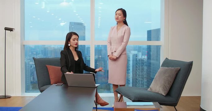 One young asian female boss getting upset and angry with her employee in the office Young Chinese business woman scold her secretary for bad job