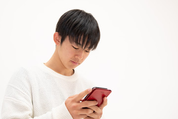 スマートフォンでゲームをする男子高校生