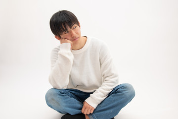 あぐらをかいて悩み事をする男子高校生