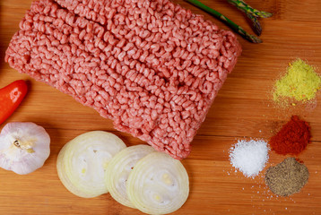 Fototapeta na wymiar Raw minced meat beef with various spices on a wooden board