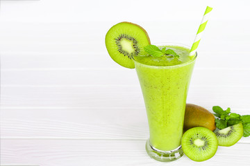 Kiwi yogurt fruit juice smoothie and green kiwi juice drink healthy, delicious taste in a glass for weight loss on a white wooden background.
