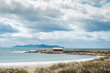 Old wooden shack on the beach in sunny Tasmania