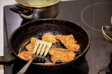 Frying chicken in a pan. Cooking potatoes.