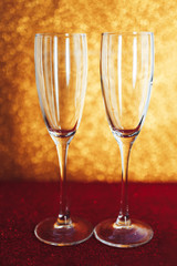 Two glasses of champagne on gold blurred background near christmas balls, gold. Happy new year.