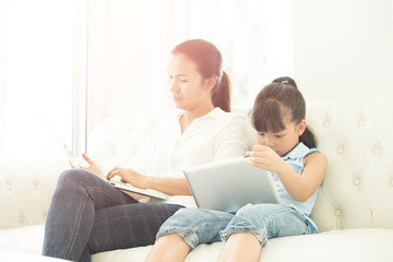 mother with daughter looking at Laptop  on sofa