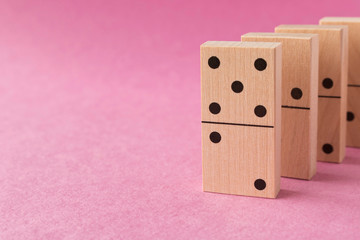 Playing dominoes on a purple background. Leisure games concept. Domino effect.