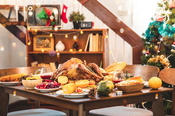 Roasted  chicken or turkey with sauce and grilled autumn vegetables: corn,pumpkin  on wooden table, top view, frame. Christmas or Thanksgiving Day food concept.