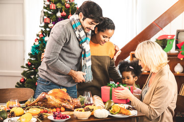 Thanksgiving Celebration Tradition Family Dinner Concept.family having holiday dinner and cutting turkey.Young black adult woman and her daughter happy.