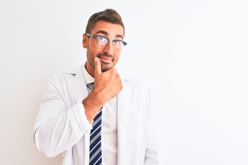 Young handsome therapist man over isolated background with hand on chin thinking about question, pensive expression. Smiling with thoughtful face. Doubt concept.