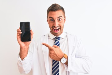 Naklejka premium Young scientist man showing smartphone screen over isolated background very happy pointing with hand and finger
