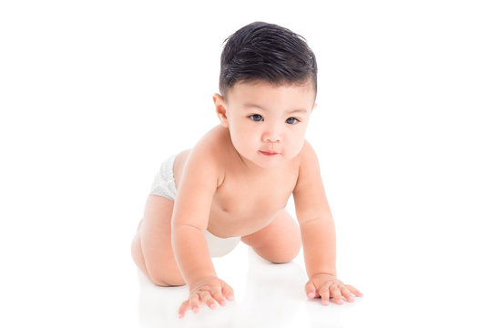 Little asian male toddler wearing diaper crawling on the floor over white background