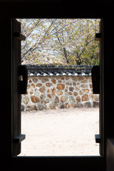Open door to Korean traditional stone wall.