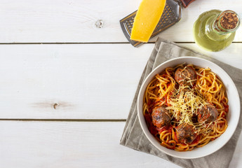 Pasta with meatballs and tomato sauce on a wooden background.