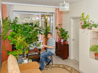 An elderly man is fond of growing houseplants