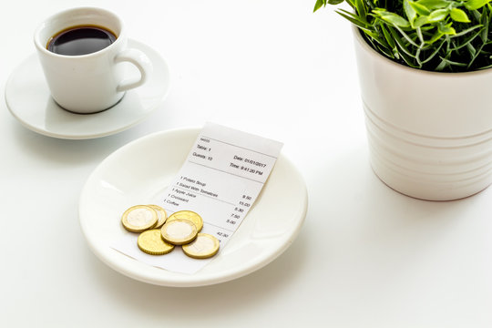 Pay Restaurant Bill By Cash. Reciept And Coins On Plate On White Background
