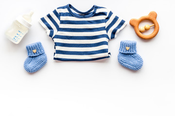Baby background - blue color. Clothes and accessories for newborn boy on white table top-down frame copy space