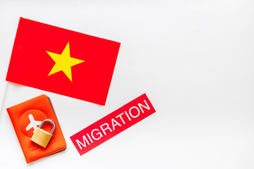 Migration to Vietman concept. Vietnamese flag near passport and lock on white background top-down copy space