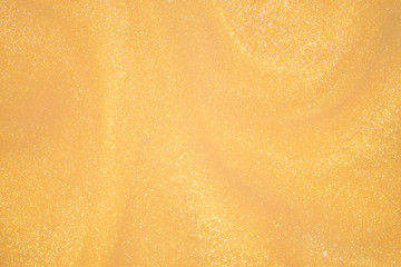 Golden glitter dust on dark background.