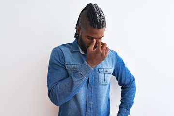 African american man with braids wearing denim shirt over isolated white background tired rubbing nose and eyes feeling fatigue and headache. Stress and frustration concept.