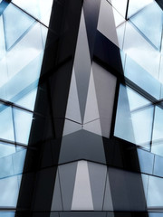 Modern office architecture. Trasparent fragments of industrial building exterior featuring windows and steel wall panels.  Abstract composition of complex geomteric structure.