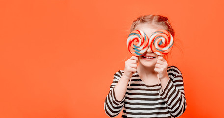 Kid girl with lollypops in front her eyes