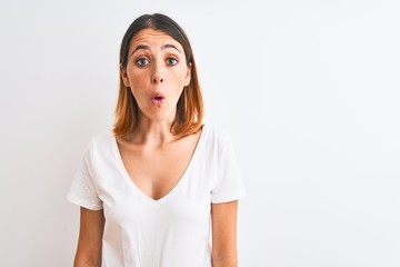 Fototapeta premium Beautiful redhead woman wearing casual white t-shirt over isolated background afraid and shocked with surprise expression, fear and excited face.